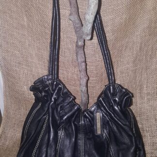 A black purse hanging on the wall