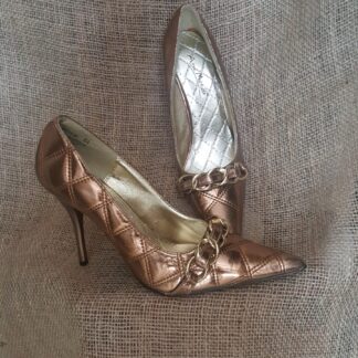 A pair of metallic shoes sitting on top of a couch.