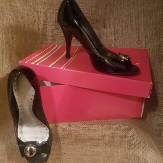 A pair of black shoes sitting on top of two pink boxes.