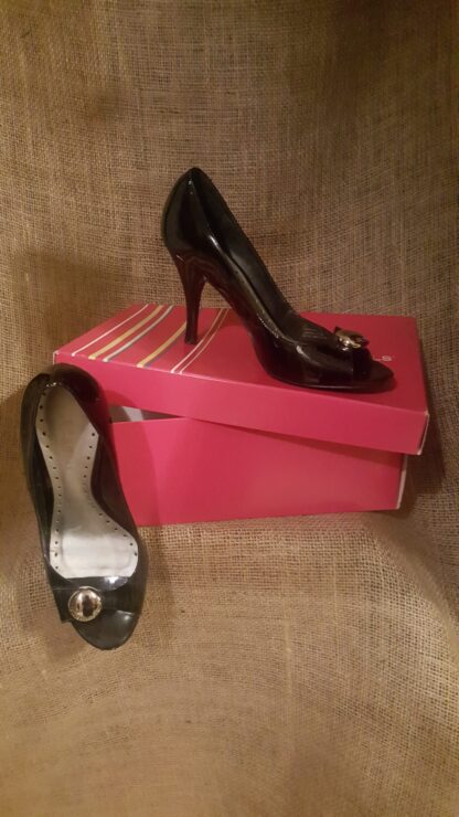 A pair of black shoes sitting on top of two pink boxes.