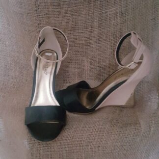 Two pairs of shoes are sitting on a chair.
