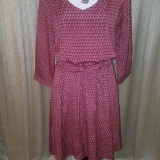 A dress that is on display in front of a curtain.