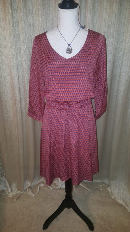 A dress that is on display in front of a curtain.