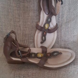 A pair of brown sandals sitting on top of a couch.