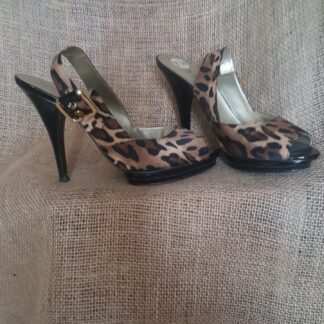A pair of leopard print shoes sitting on top of a couch.