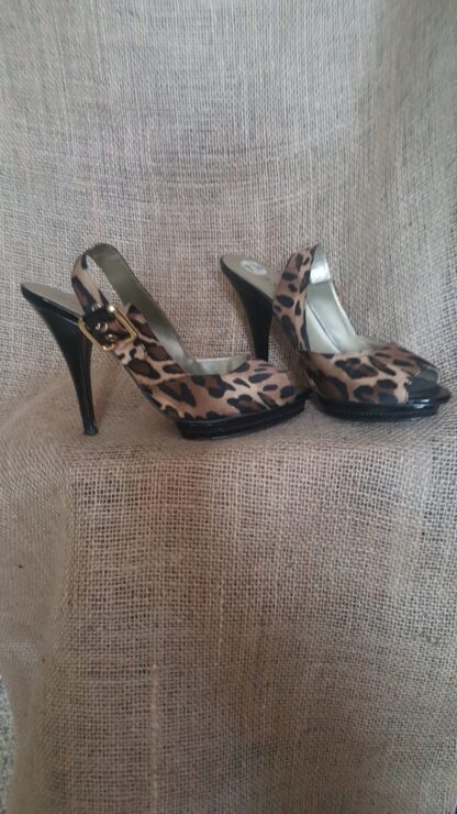 A pair of leopard print shoes sitting on top of a couch.