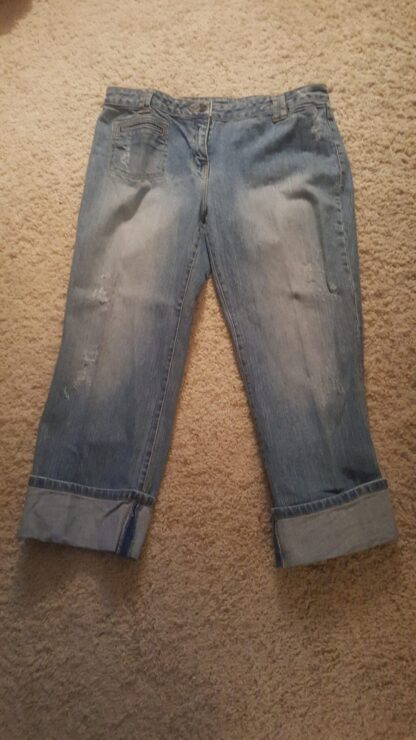 A pair of jeans that are on the floor.
