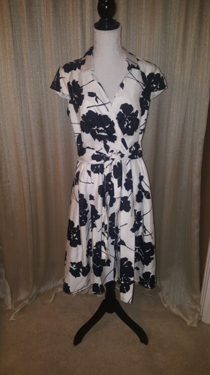 A dress that is on display in front of a curtain.