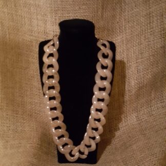 A necklace is displayed on the black mannequin.