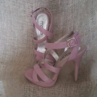 A pair of pink shoes sitting on top of a brown couch.
