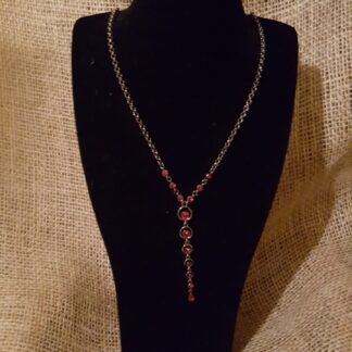 A necklace is displayed on a black display stand.