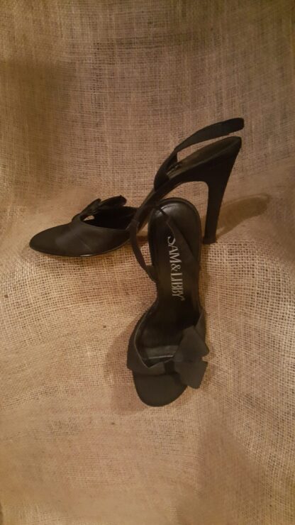 A pair of black high heels sitting on top of a floor.