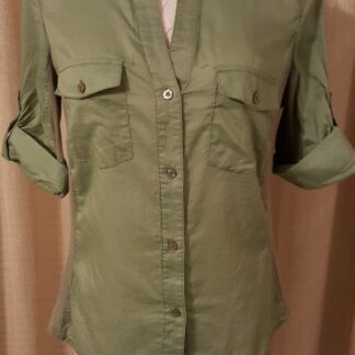 A green shirt is on display with the sleeves rolled up.