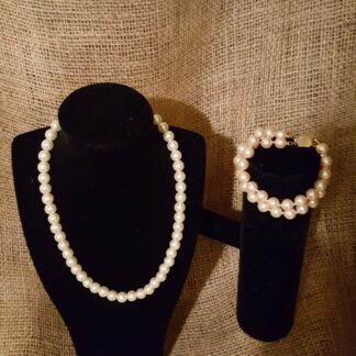 A black velvet display with pearls and a bracelet