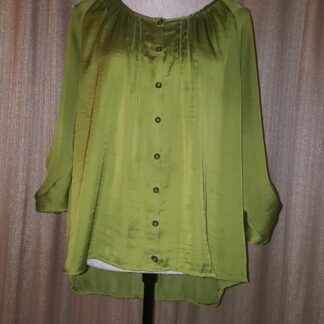 A green blouse is on display against the wall.