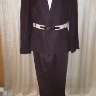 A suit that is on display in front of a curtain.
