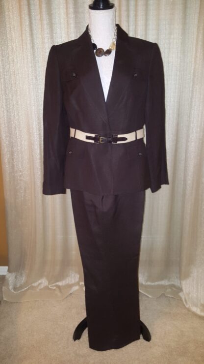 A suit that is on display in front of a curtain.