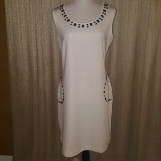 A white dress with black and silver beads on the neck.