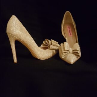 A pair of white shoes with bows on them.