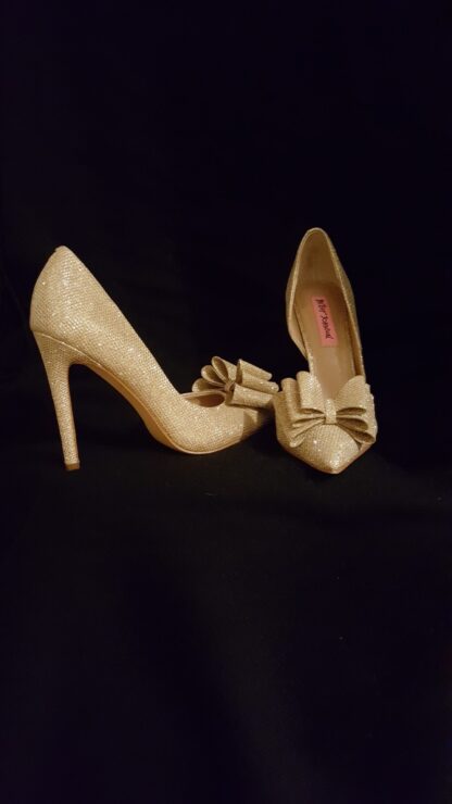 A pair of white shoes with bows on them.