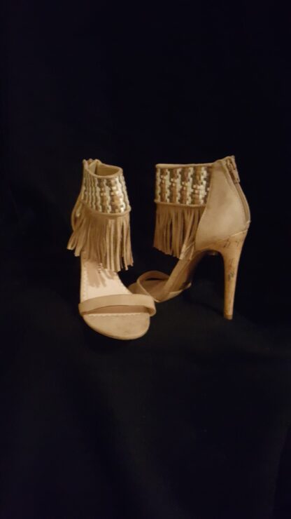 A pair of high heels with fringes on them.