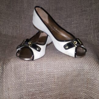 A pair of white and black shoes sitting on top of a couch.