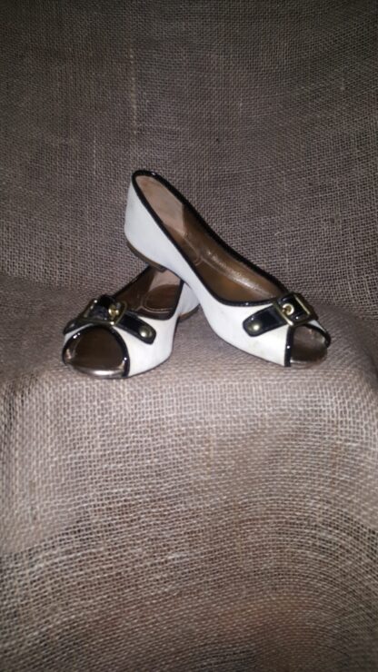 A pair of white and black shoes sitting on top of a couch.