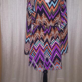 A dress that is on display in front of a curtain.