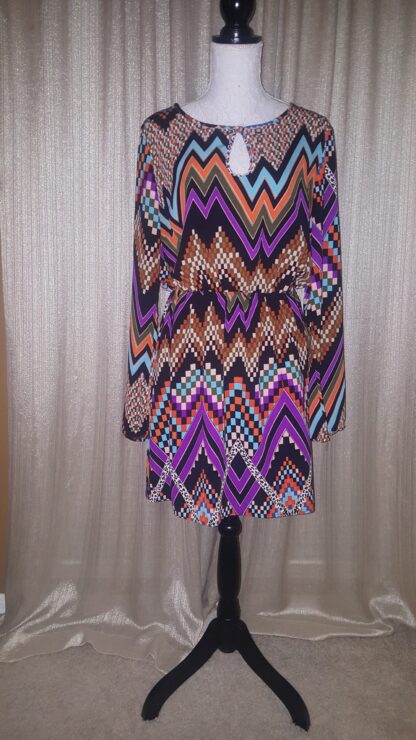 A dress that is on display in front of a curtain.