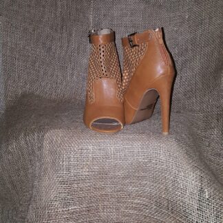 A pair of brown shoes sitting on top of a couch.