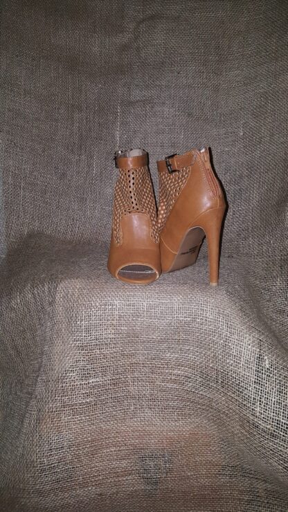 A pair of brown shoes sitting on top of a couch.