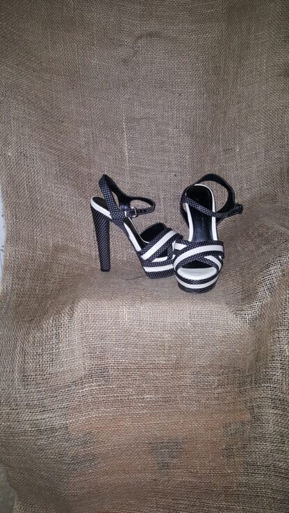 A pair of black and white shoes on top of a chair.
