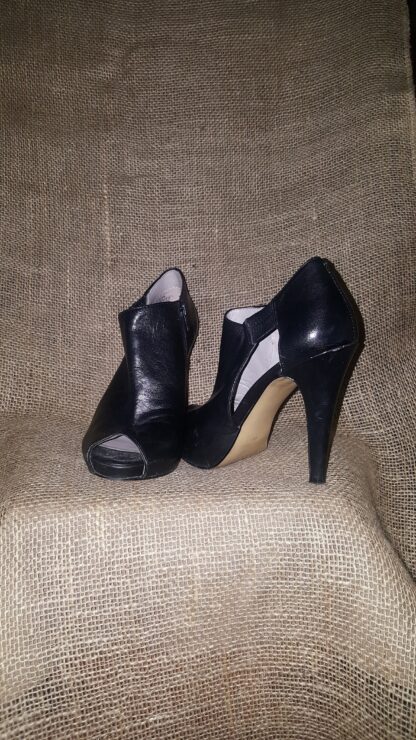 A pair of black shoes sitting on top of a chair.