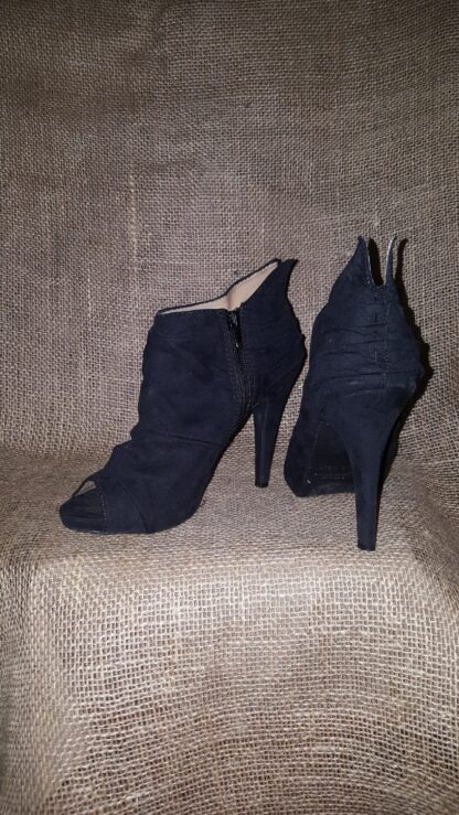 A pair of black shoes sitting on top of a chair.