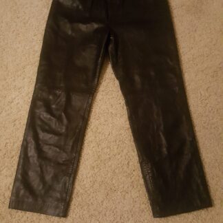 A pair of black leather pants hanging on the wall.