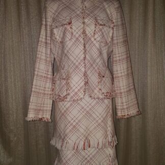 A suit that is on display in front of a curtain.