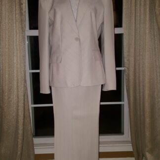 A woman 's suit is shown in front of a window.