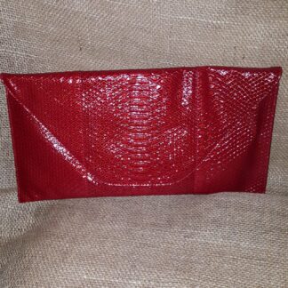 A red purse sitting on top of a couch.