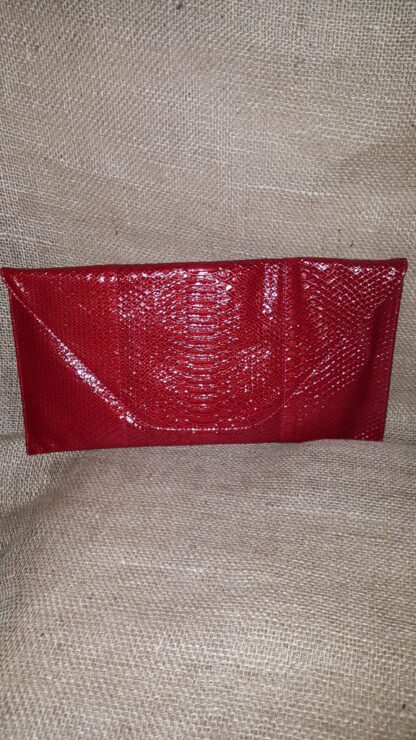 A red purse sitting on top of a couch.