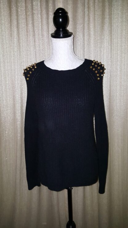 A black sweater with gold studs on the shoulders.