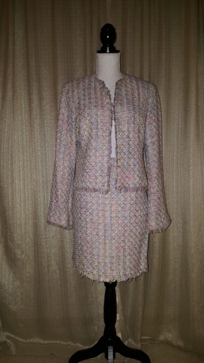 A woman 's suit is shown in front of a curtain.