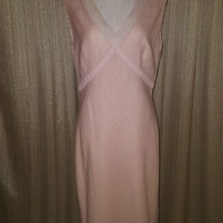 A pink dress is standing up against the wall