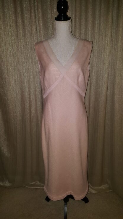 A pink dress is standing up against the wall