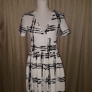 A dress that is on display in front of a curtain.