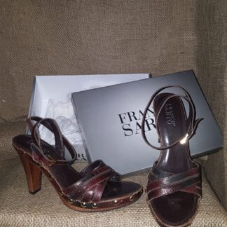 A pair of brown shoes sitting on top of a box.
