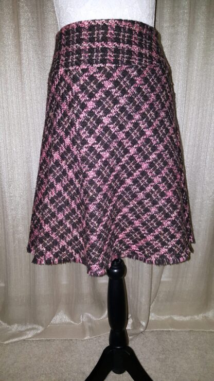 A pink and black checkered skirt is shown on the mannequin.