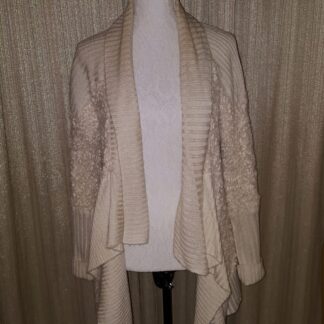 A white sweater is draped over the shoulders.