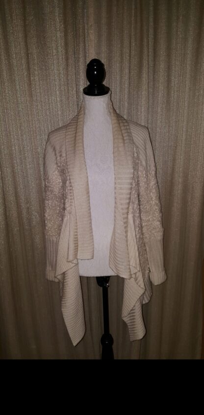 A white sweater is draped over the shoulders.