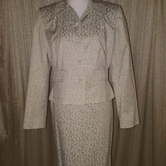 A woman 's suit is shown in front of a curtain.