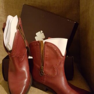 A pair of boots sitting next to a purse.